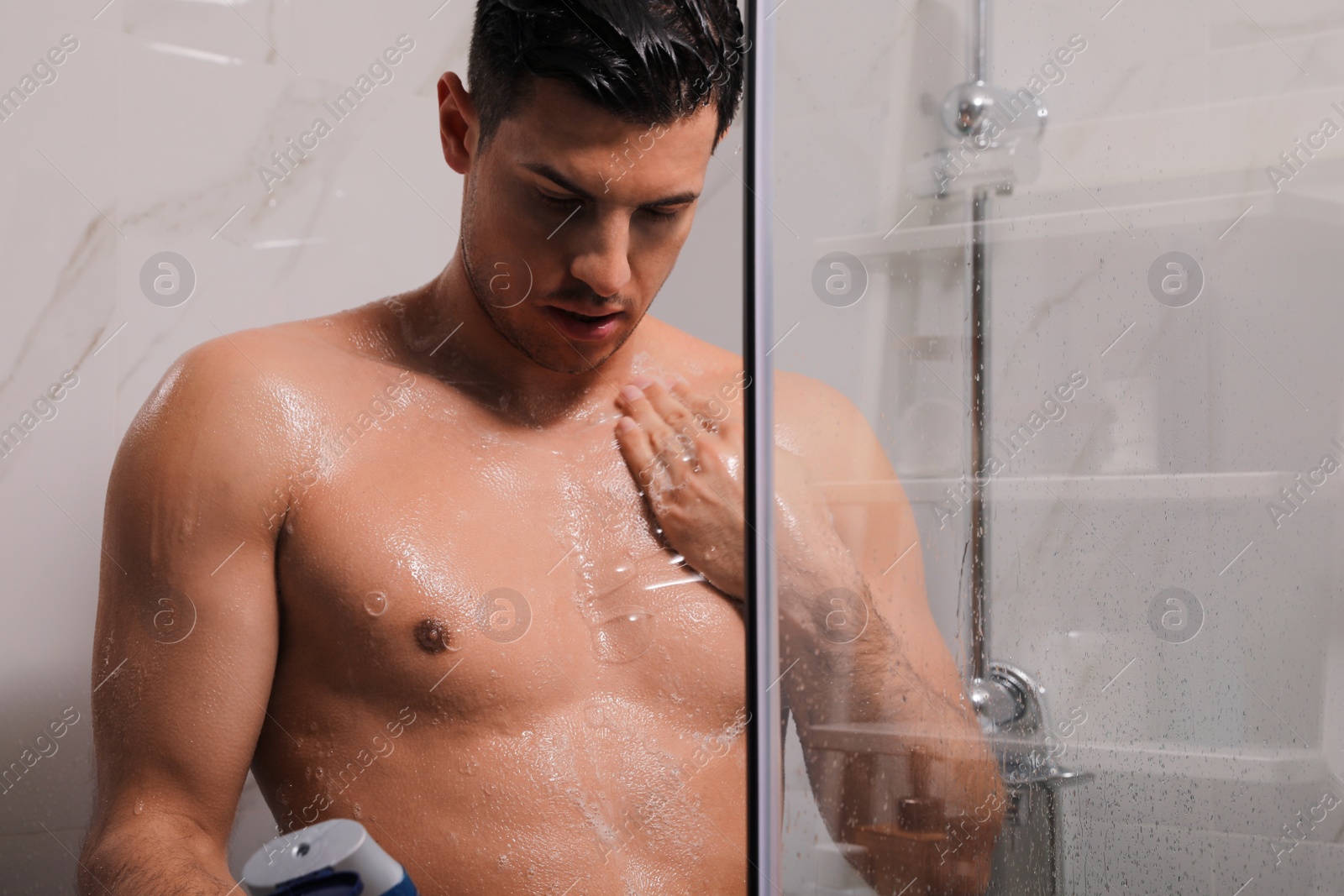 Photo of Man using gel in shower at home