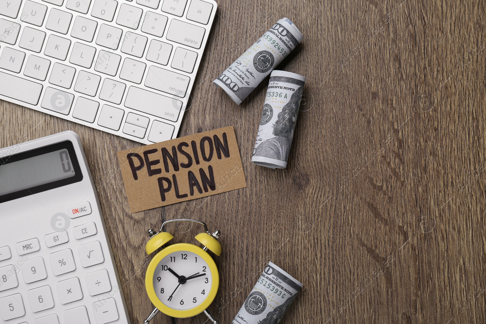 Photo of Card with words Pension Plan, banknotes, calculator and alarm clock on wooden office table, flat lay. Space for text