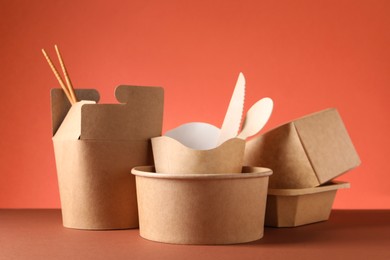 Photo of Eco friendly food packaging. Paper containers and tableware on color background