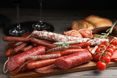 Photo of Different tasty sausages on wooden table, closeup