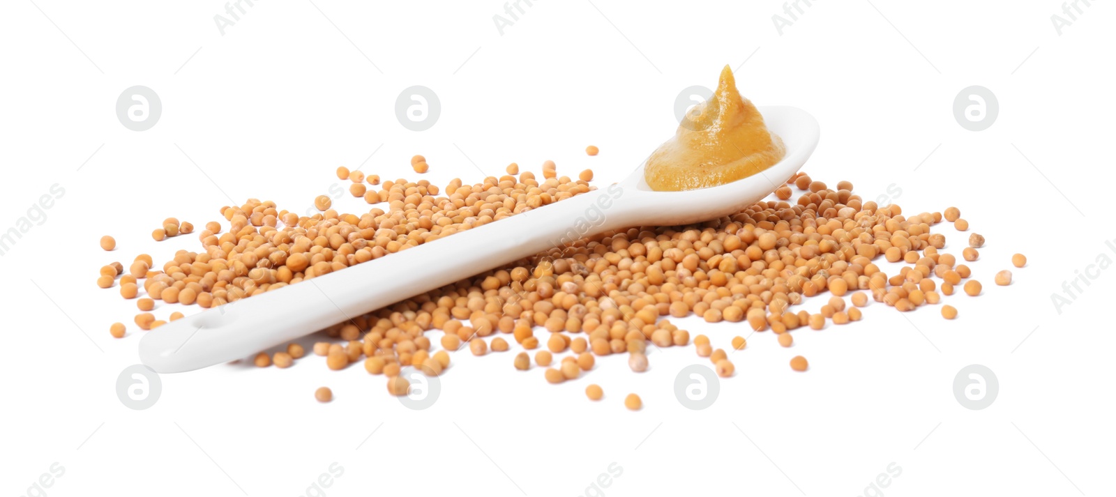 Photo of Fresh tasty mustard sauce in spoon and dry seeds isolated on white