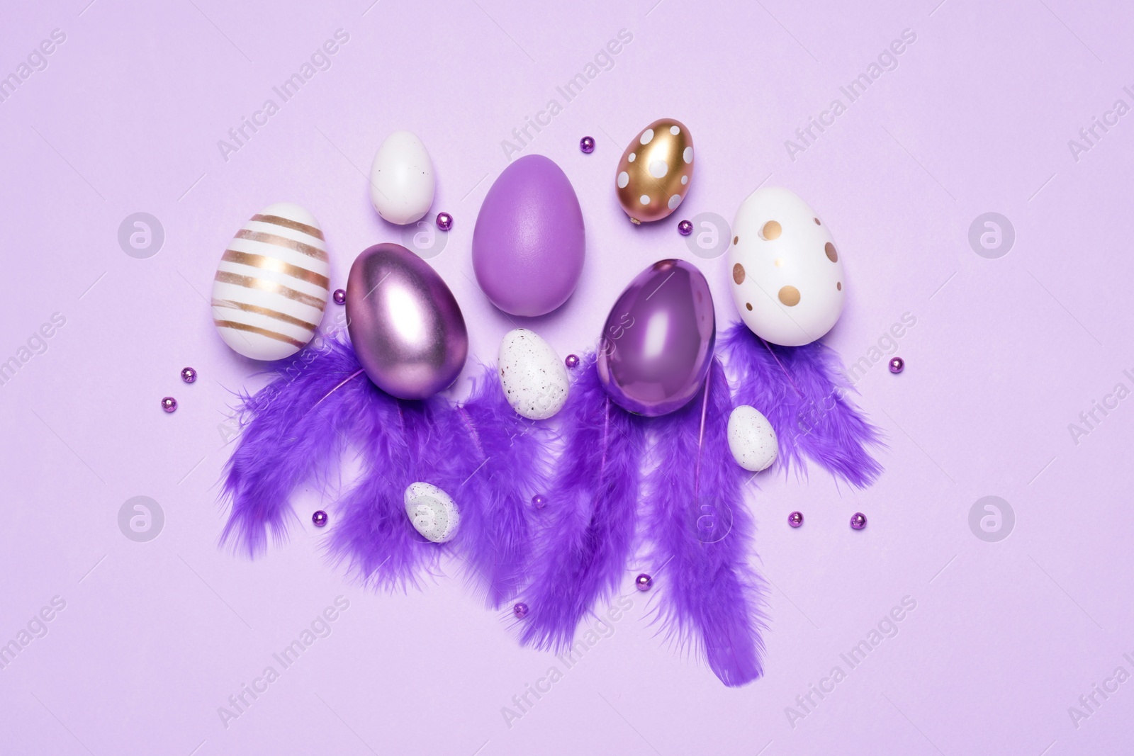 Photo of Flat lay composition with festively decorated Easter eggs on lilac background