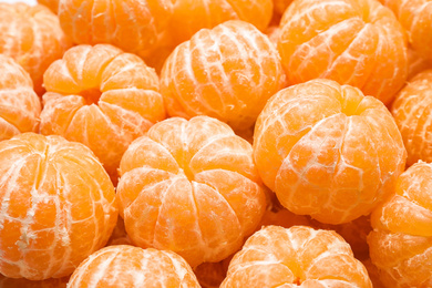 Peeled fresh ripe tangerines as background, closeup