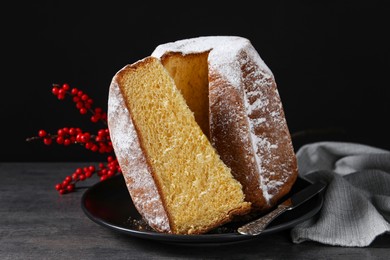 Photo of Delicious Pandoro cake with powdered sugar and decor on grey table. Traditional Italian pastry
