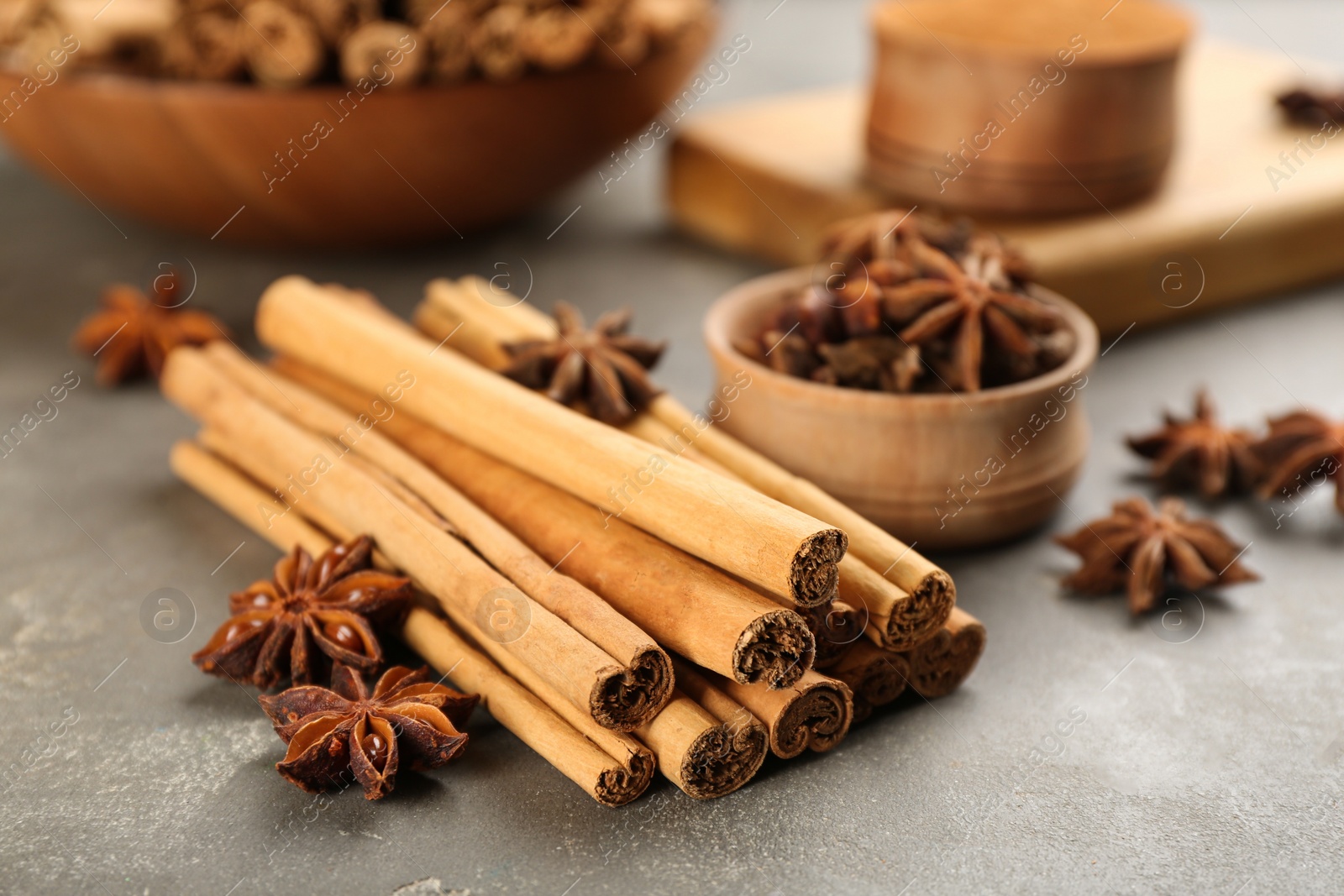 Photo of Aromatic cinnamon sticks and anise on grey table