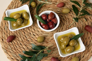 Olives and tree twigs on beige table, above view