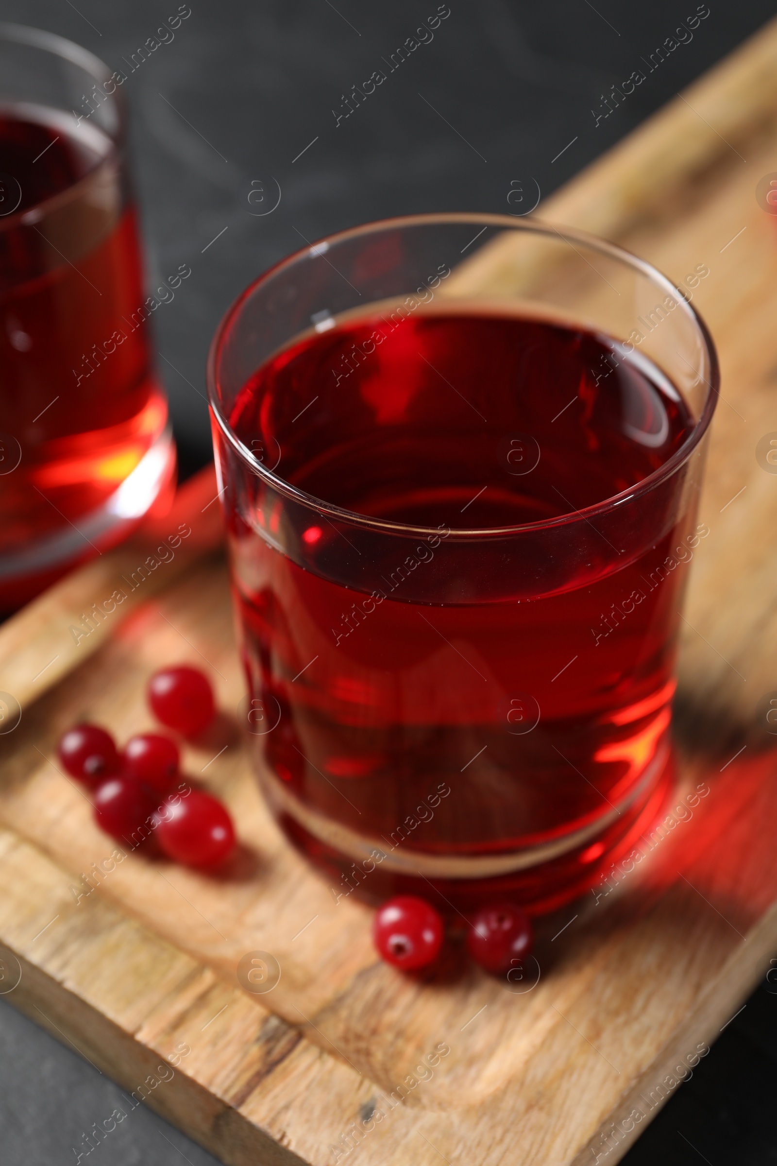 Photo of Tasty refreshing cranberry juice and fresh berries on grey table