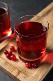 Photo of Tasty refreshing cranberry juice and fresh berries on grey table