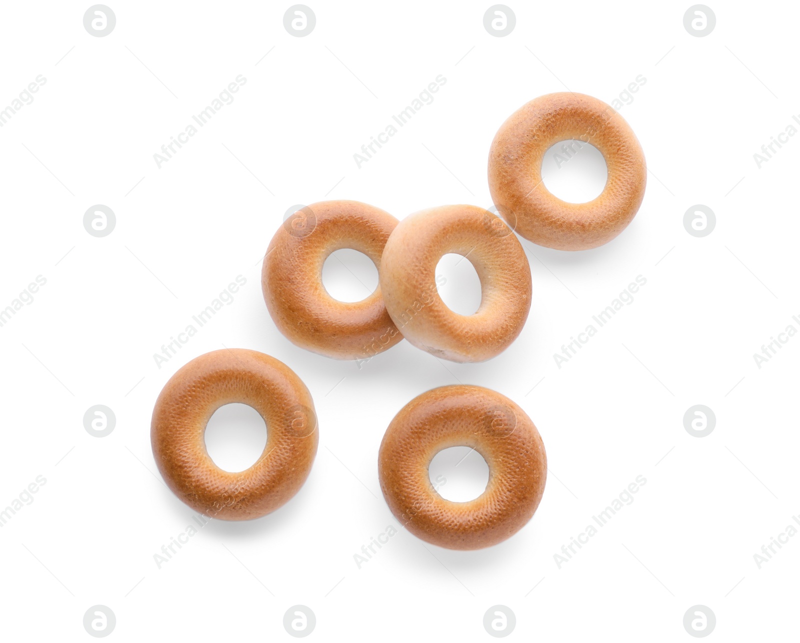 Photo of Many tasty dry bagels (sushki) isolated on white, top view