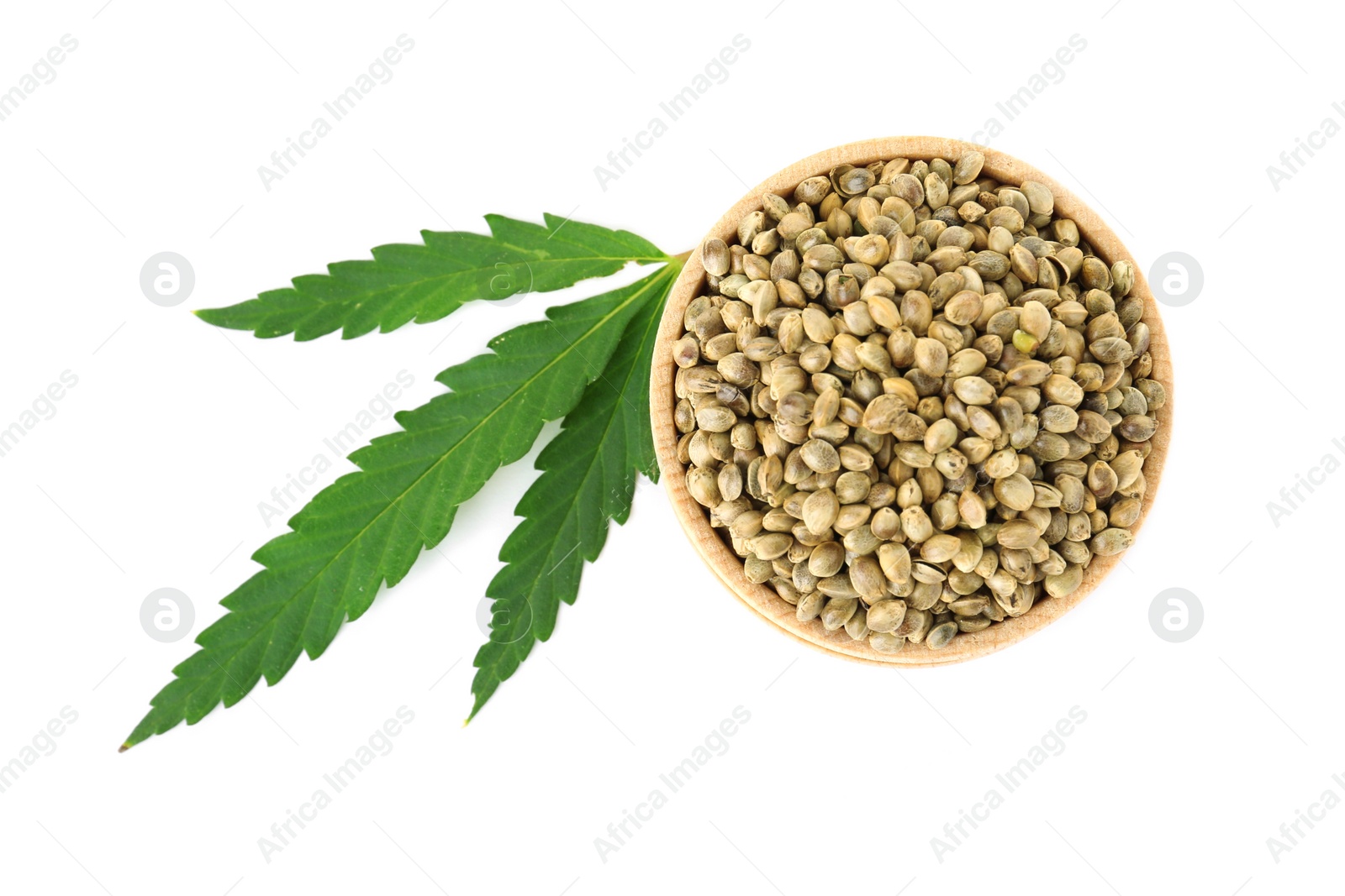 Photo of Bowl of hemp seeds with green leaf on white background, top view