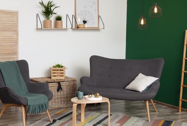 Photo of Modern living room interior stylish sofa near green wall