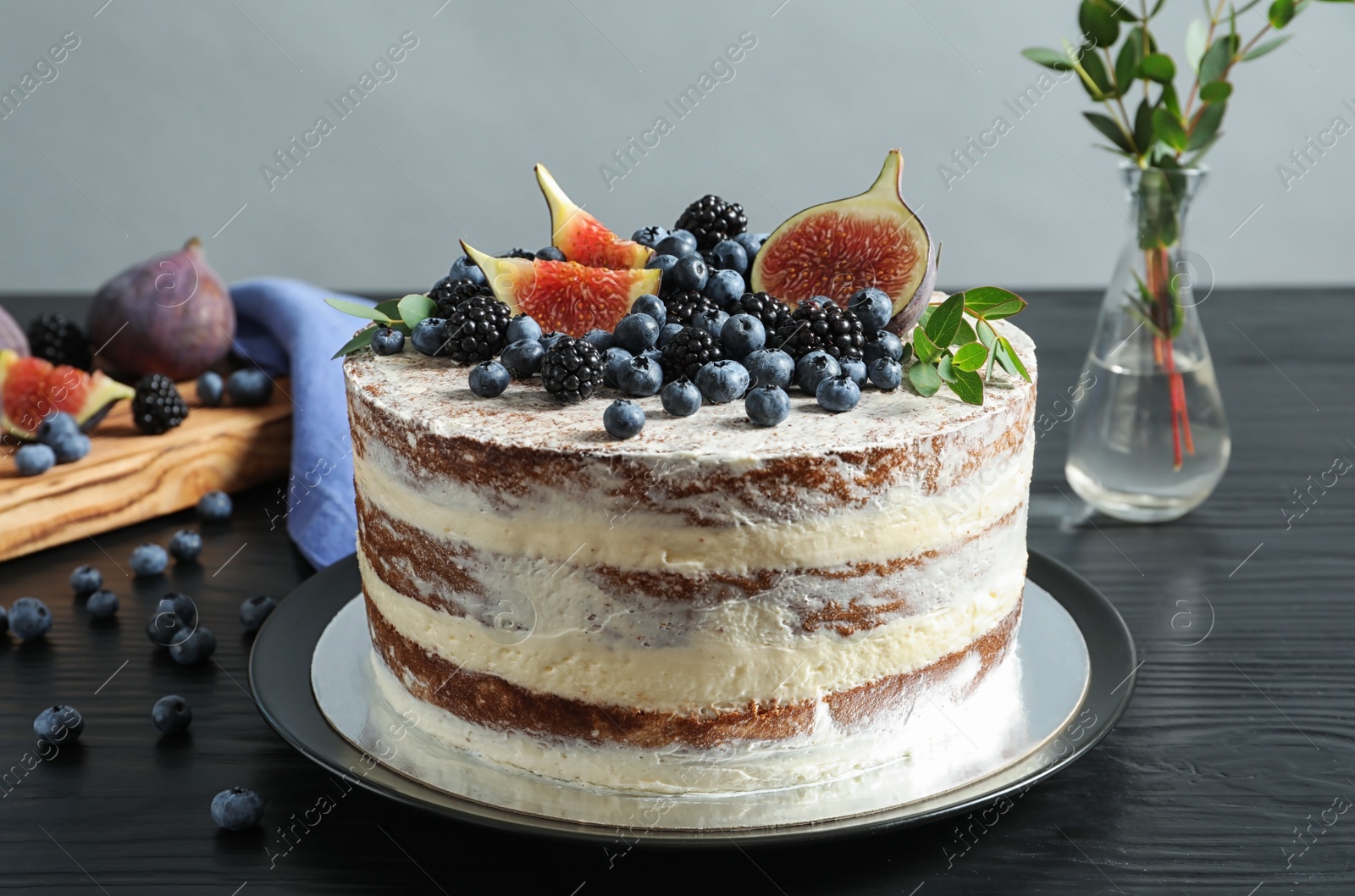 Photo of Delicious homemade cake with fresh berries served on dark wooden table