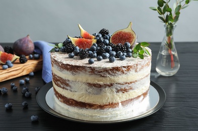 Delicious homemade cake with fresh berries served on dark wooden table