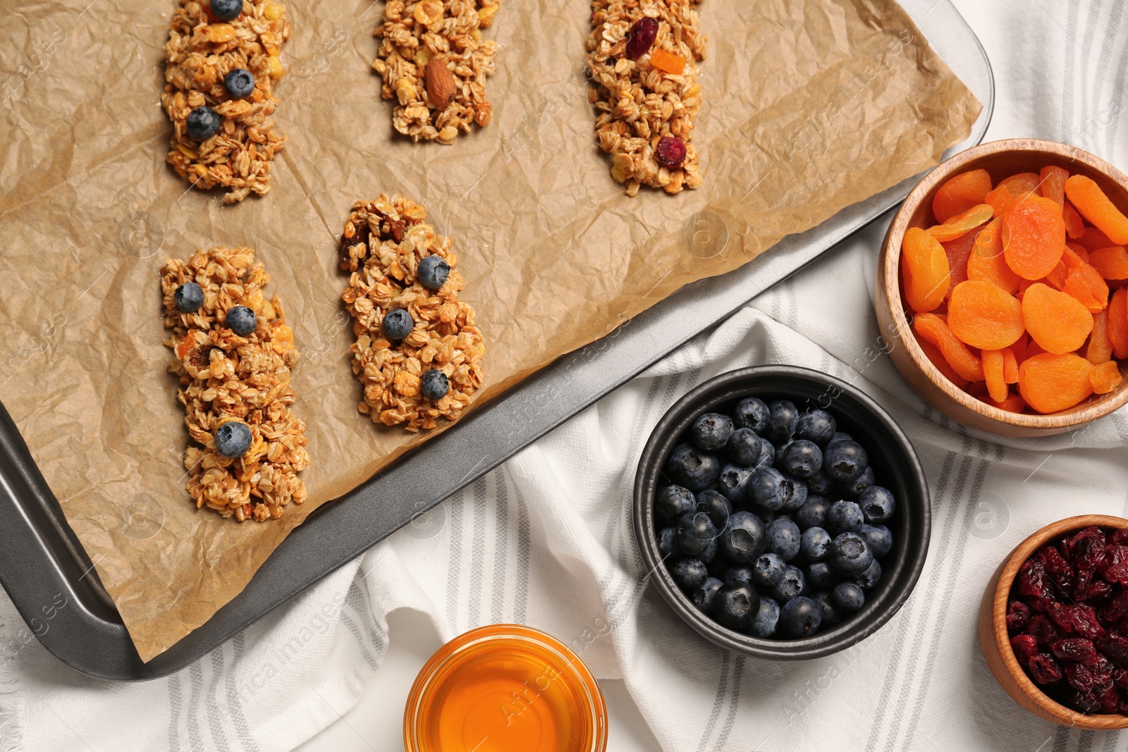 Photo of Making granola bars. Baking tray and ingredients on table, flat lay