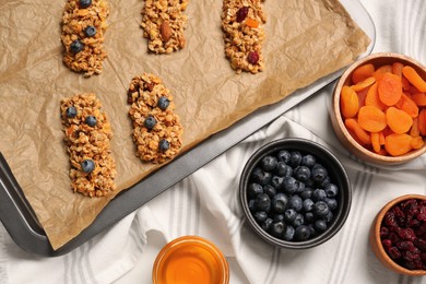 Photo of Making granola bars. Baking tray and ingredients on table, flat lay