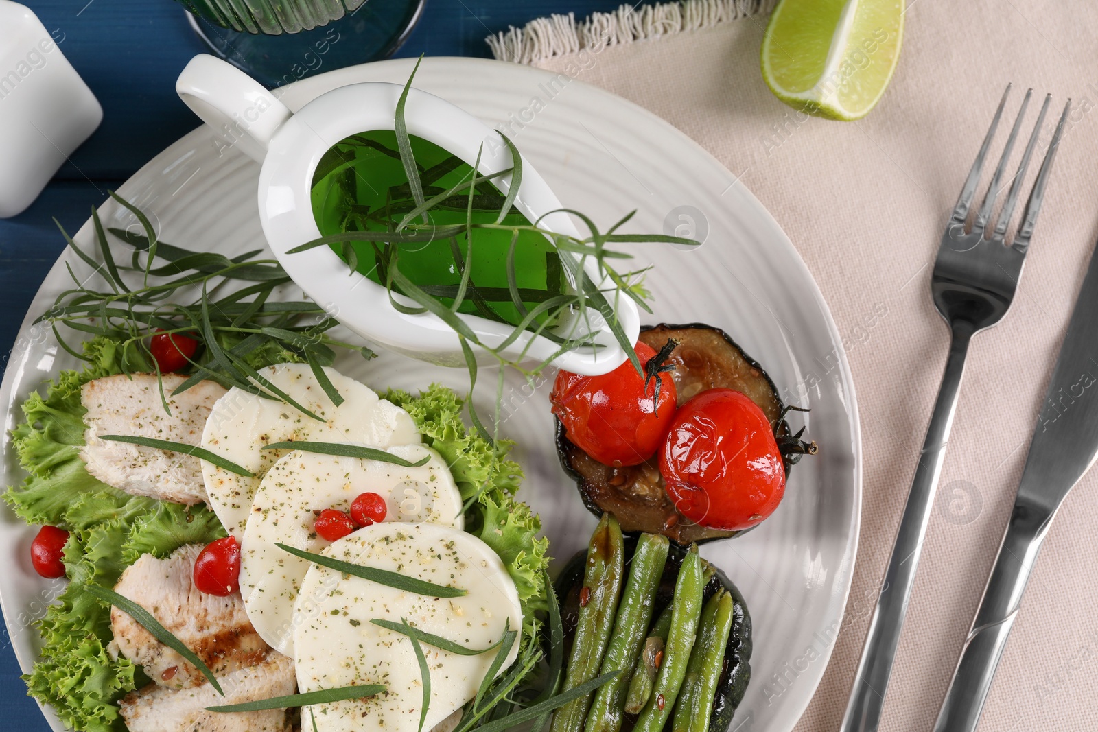 Photo of Tasty mozzarella, chicken and vegetables with tarragon served on table, flat lay
