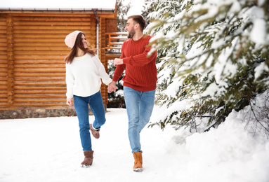 Lovely couple walking together on snowy day. Winter vacation