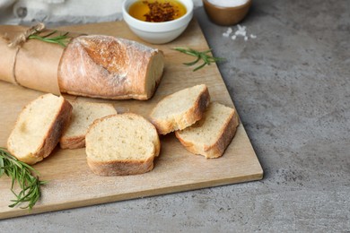 Photo of Fresh crispy baguette on grey table. Space for text