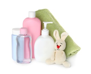 Bottles of baby cosmetic products, towel and toy bunny on white background