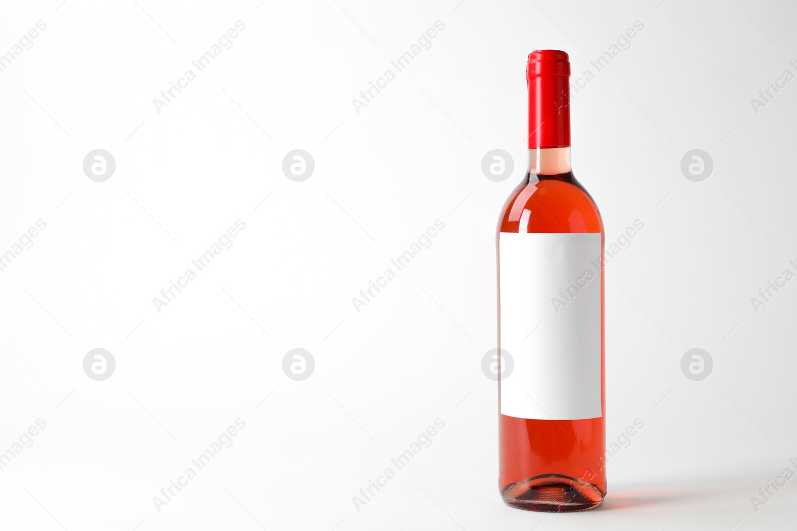 Photo of Bottle of delicious wine with blank label on white background