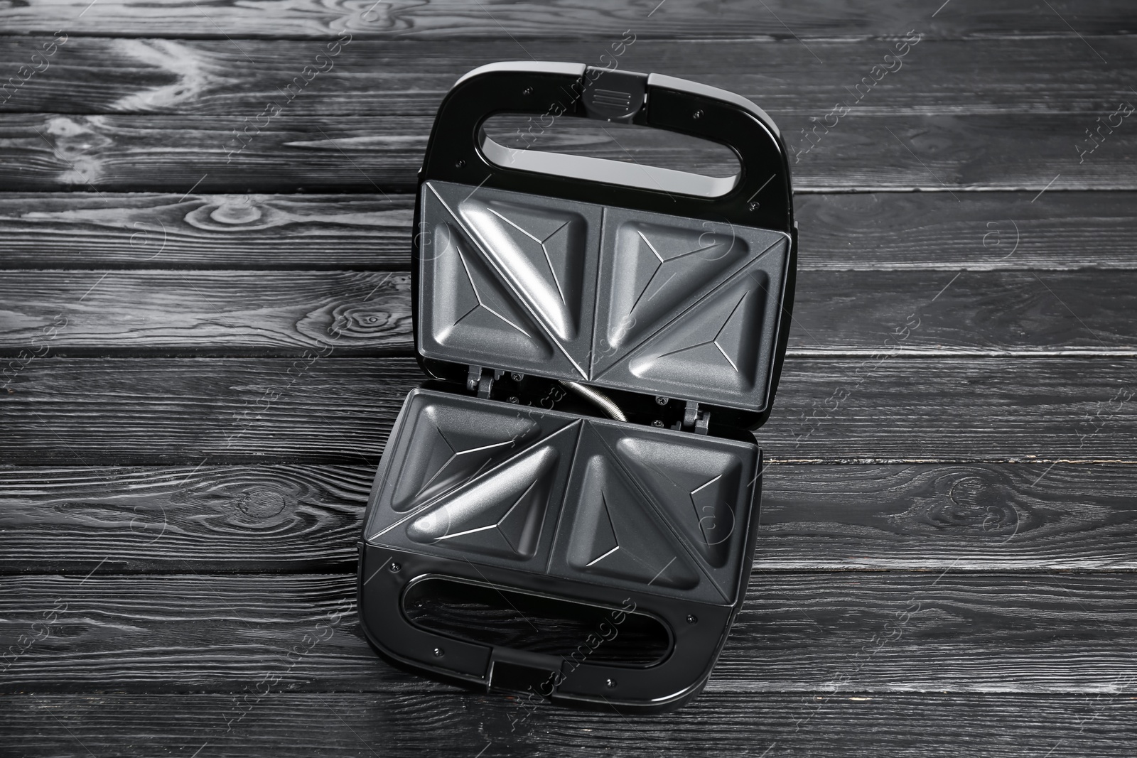 Photo of Open modern sandwich maker on black wooden table