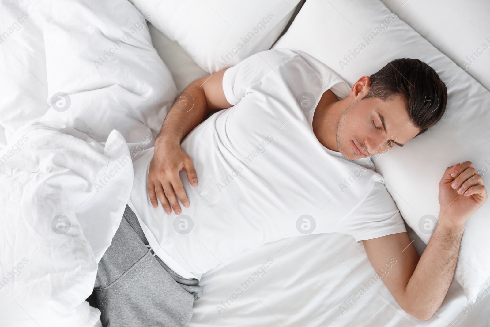 Photo of Portrait of handsome man sleeping in large bed, above view