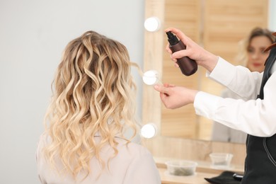 Hair styling. Professional hairdresser working with client in salon, closeup