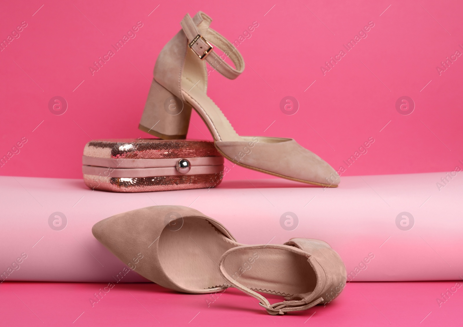 Photo of Stylish female shoes and bag on pink background