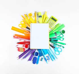 Composition with different school stationery and open blank notebook on white background, top view