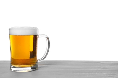 Photo of Glass mug of tasty beer on wooden table against white background