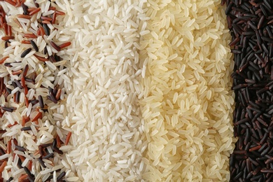 Photo of Brown and other types of rice as background, closeup