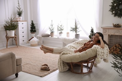 Photo of Woman resting in comfortable papasan chair at home