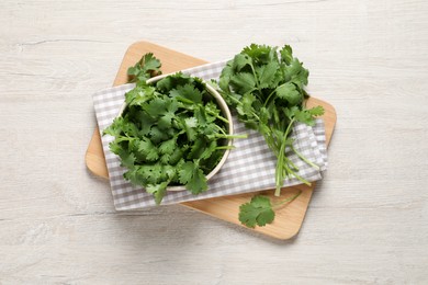 Bunch of fresh aromatic cilantro on white wooden table, top view