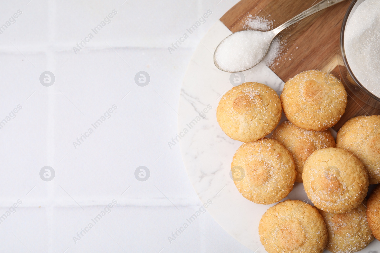 Photo of Tasty sweet sugar cookies on white tiled table, top view. Space for text