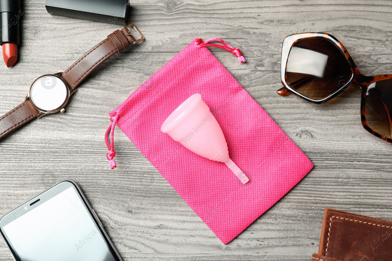 Photo of Menstrual cup and different women's accessories on wooden table, flat lay
