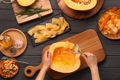 Photo of Woman slicing fresh pumpkin at grey wooden table, top view