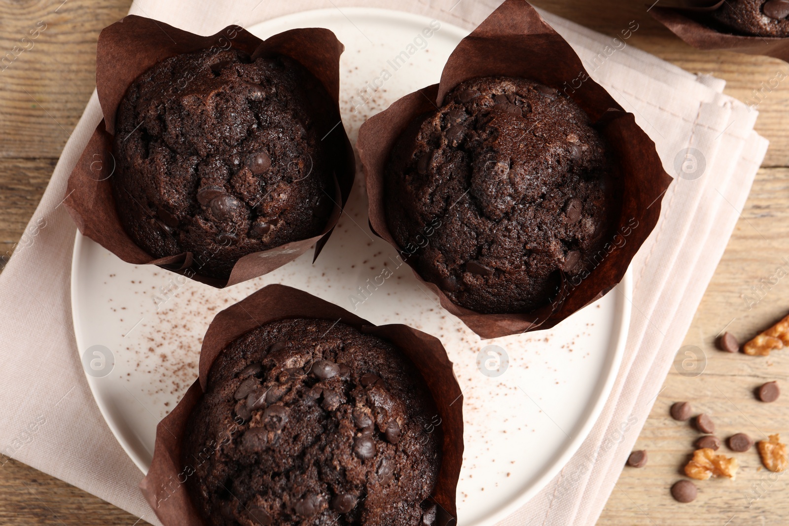 Photo of Tasty chocolate muffins on wooden table, flat lay