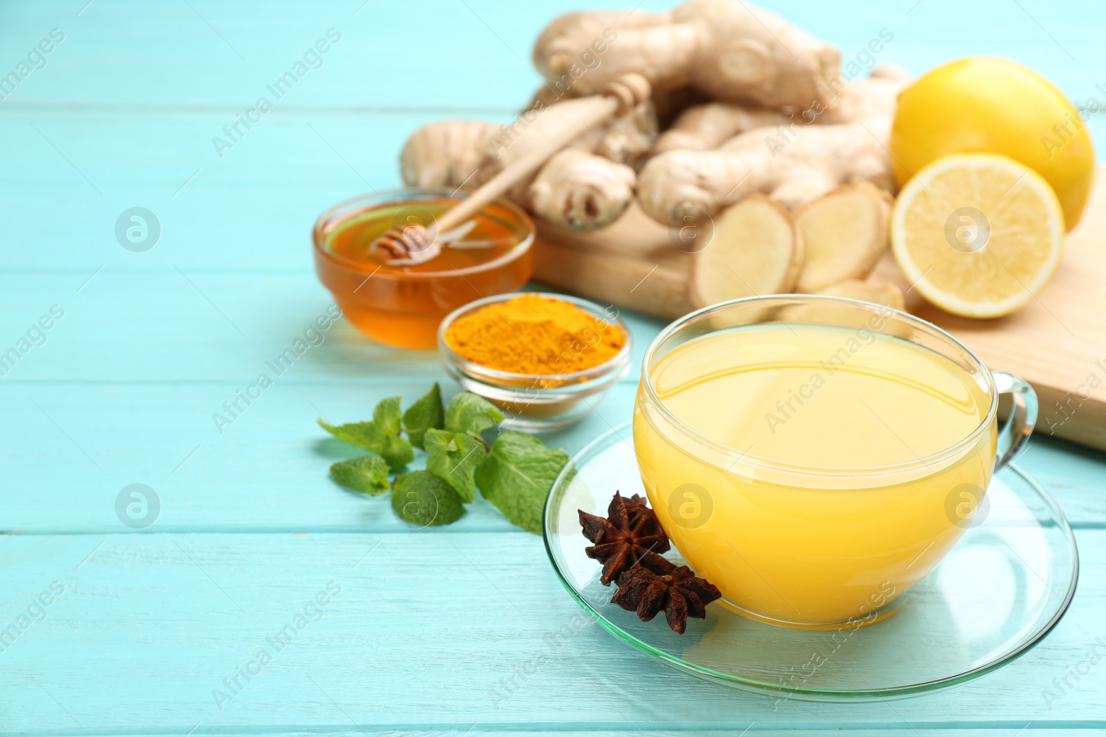 Photo of Immunity boosting drink and ingredients on turquoise wooden table. Space for text