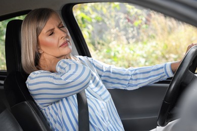 Woman suffering from neck pain in car