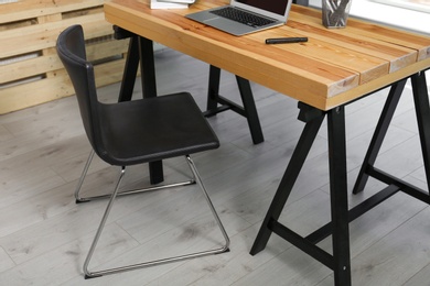 Photo of Comfortable workplace with office chair and wooden table