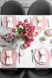 Festive table setting with beautiful flowers, top view. Easter celebration