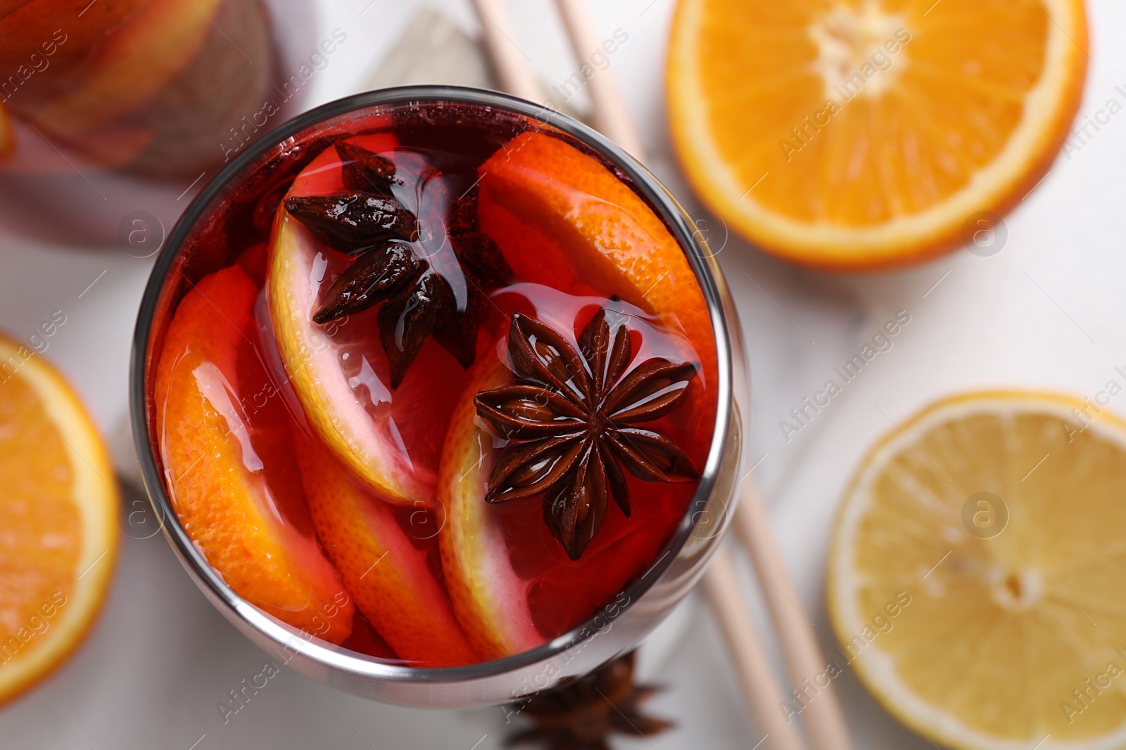 Photo of Aromatic punch drink and ingredients on white table, flat lay