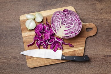 Photo of Cut fresh red cabbage and knife on wooden table, flat lay