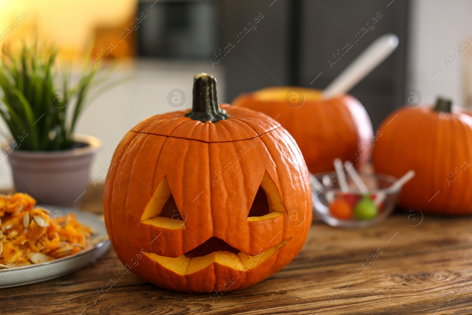 Photo of Pumpkin jack o'lantern on wooden table indoors. Halloween celebration