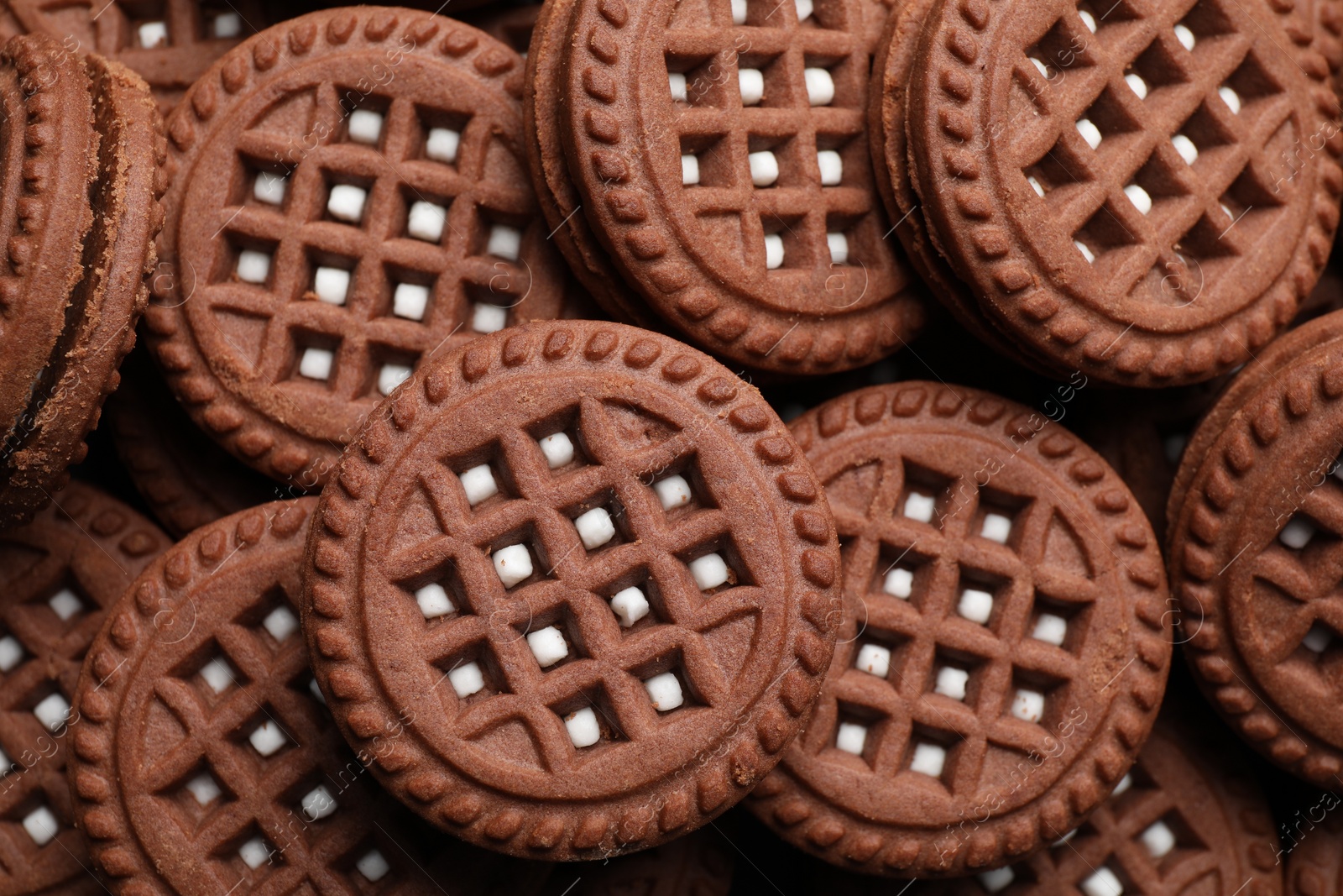 Photo of Tasty chocolate sandwich cookies with cream as background, top view