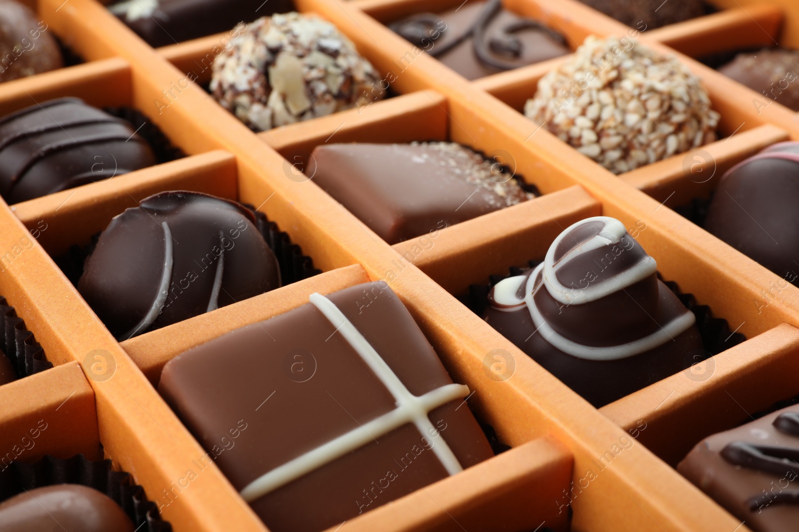 Photo of Box with different chocolate candies as background, closeup