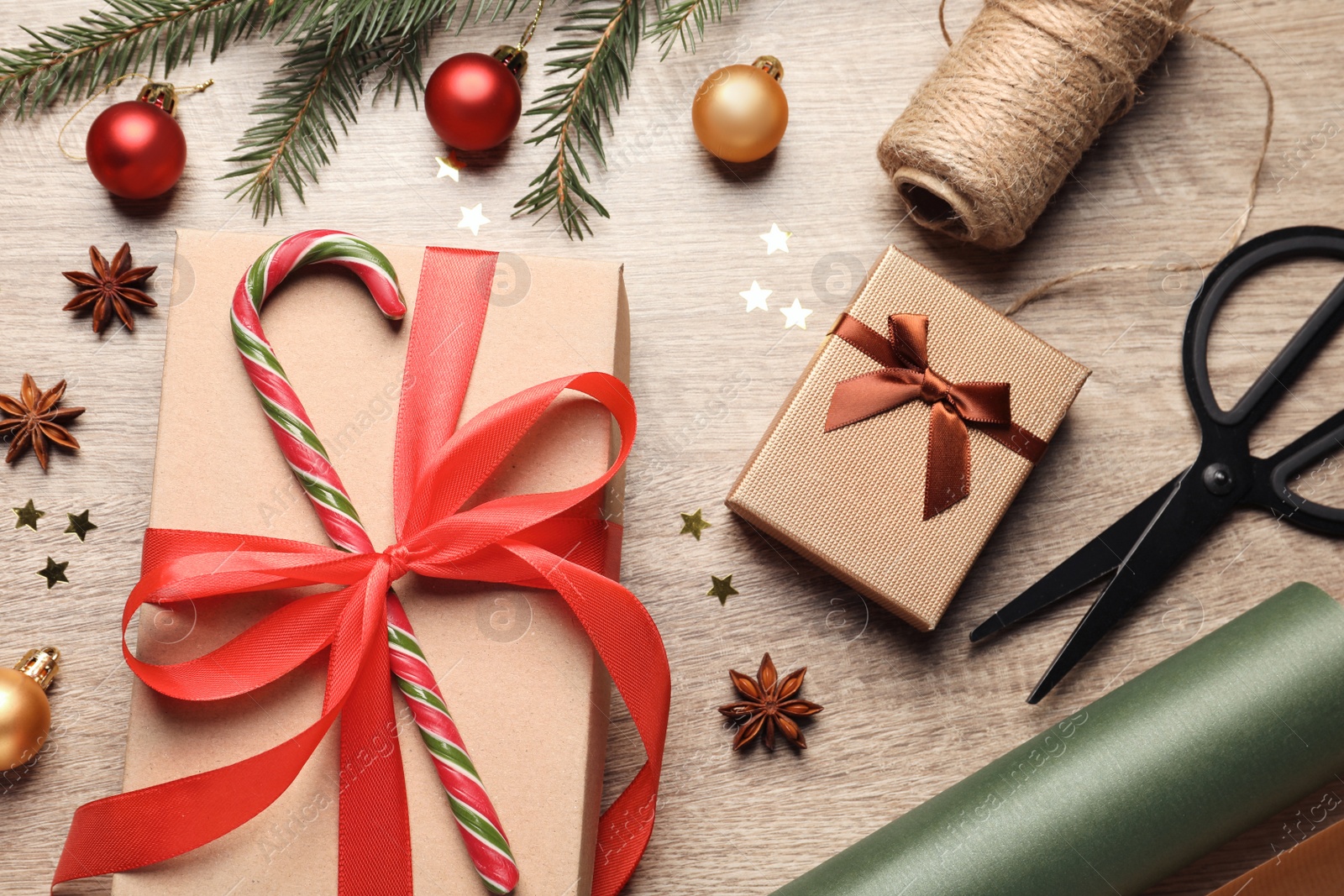 Photo of Flat lay composition with beautiful Christmas gift boxes and wrapping paper on wooden table