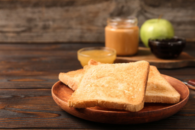 Photo of Crispy toasts on wooden table. Delicious breakfast