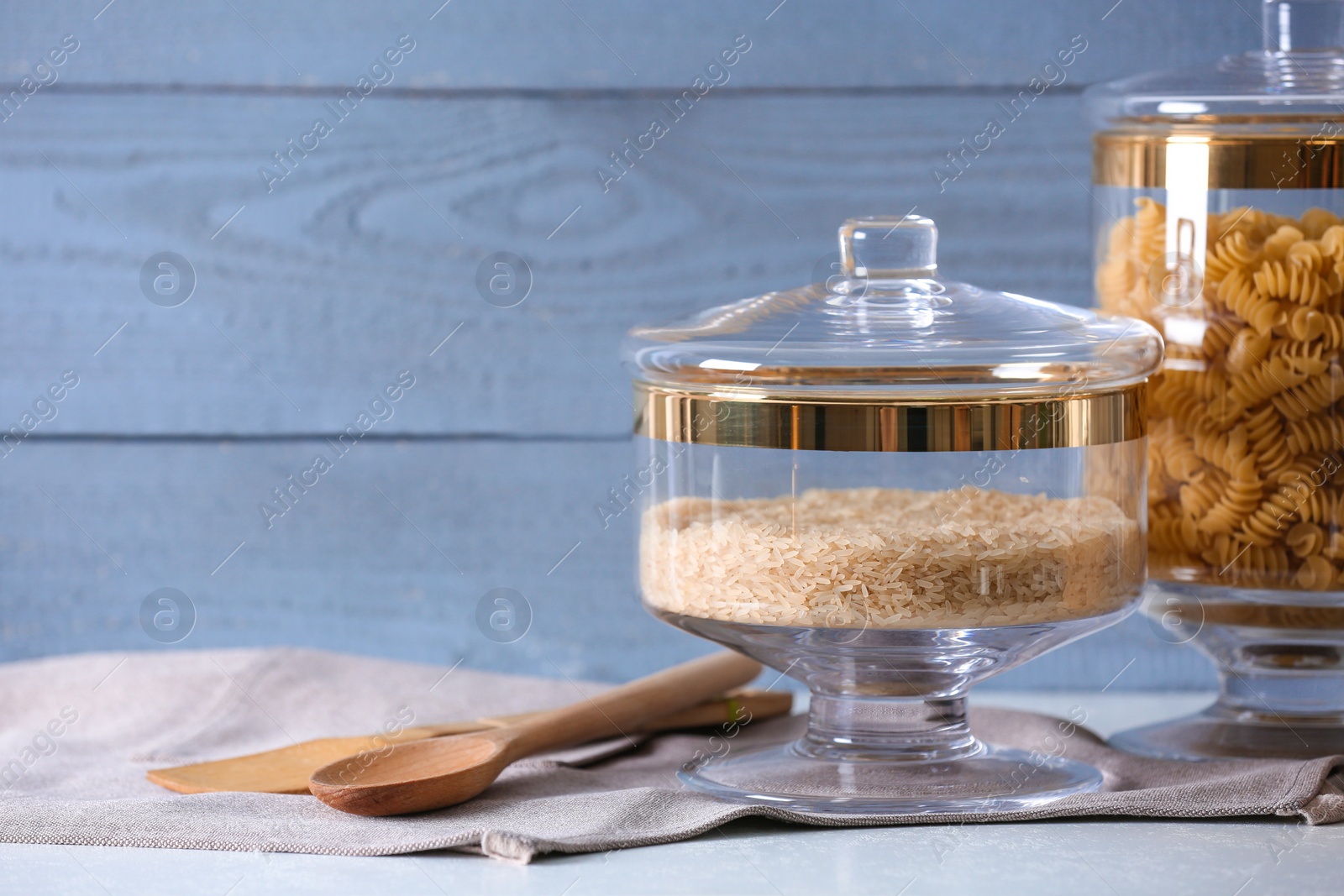 Photo of Cereals on grey table against blue wooden background, space for text. Foodstuff for modern kitchen