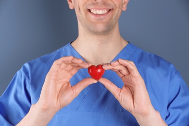 Photo of Doctor holding small heart, closeup. Prevent heart attack